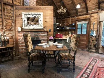 a dining room with a table and chairs and a fireplace at Secluded and Rustic Cabin Rental with Modern Amenities near Woodstock, New York in Willow
