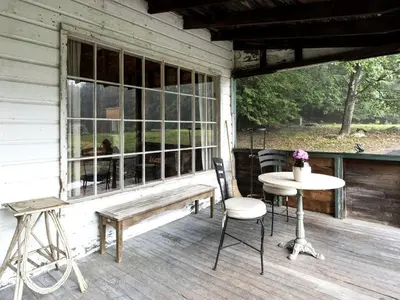 a porch with a table and chairs and a window at Secluded and Rustic Cabin Rental with Modern Amenities near Woodstock, New York in Willow