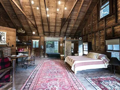 a bedroom with a bed in a room with wooden walls at Secluded and Rustic Cabin Rental with Modern Amenities near Woodstock, New York in Willow