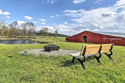 a bench sitting in a field next to a red barn at Great Vacation Complex for the Best Pennsylvania Glamping in Scranton