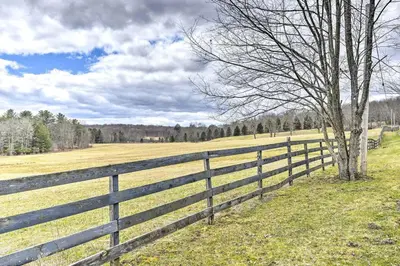 a wooden fence in a field with a tree at Great Vacation Complex for the Best Pennsylvania Glamping in Scranton