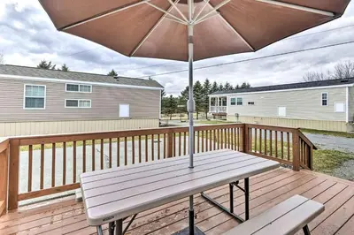 a wooden deck with a bench and an umbrella at Remote Ski Rentals for a Gorgeous Pennsylvania Retreat in Pleasant Mount
