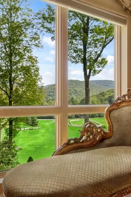 a chair in front of a window with a view at Spacious Villa Rental with a Pool for a Large Group near Catskill Mountains, New York in Fishs Eddy