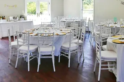 a dining room with white tables and white chairs at 27-Person Luxury Villa Rental in Hudson Valley, New York in Monroe