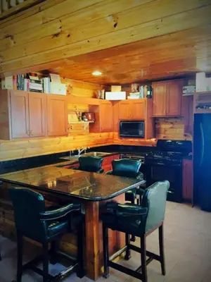 a kitchen with a table and chairs in a cabin at Fantastic Secluded Rental for a Large Group Getaway near East Branch, New York in Fishs Eddy