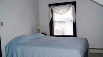 a bedroom with a bed and a window at Hilltop Cottage Rental Overlooking Creek near Albany in Upstate New York in Fly Creek