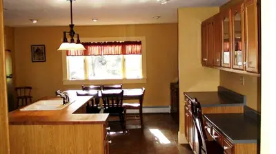 a kitchen with a sink and a table and a window at Hilltop Cottage Rental Overlooking Creek near Albany in Upstate New York in Fly Creek