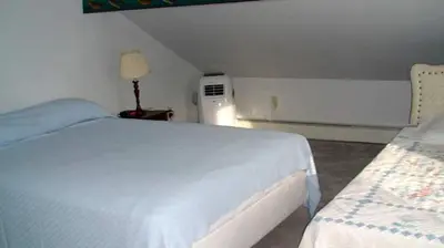 a bedroom with a bed and a air conditioner at Hilltop Cottage Rental Overlooking Creek near Albany in Upstate New York in Fly Creek