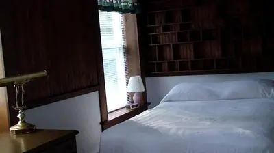 a bedroom with a white bed and a window at Hilltop Cottage Rental Overlooking Creek near Albany in Upstate New York in Fly Creek