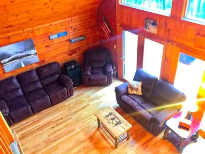 a living room with two couches and a coffee table at Spacious Log Cabin for a Family Getaway near the Zoar Outdoor Adventure Resort in Massachusetts in Charlemont