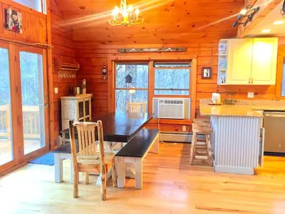 a kitchen with a table and chairs in a cabin at Spacious Log Cabin for a Family Getaway near the Zoar Outdoor Adventure Resort in Massachusetts in Charlemont