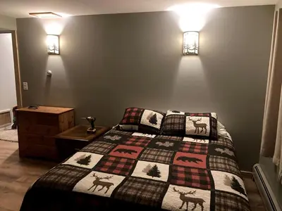 a bedroom with a bed with a quilt on it at Spacious Log Cabin for a Family Getaway near the Zoar Outdoor Adventure Resort in Massachusetts in Charlemont