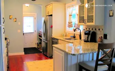 a kitchen with a counter and a sink and a refrigerator at Charming Waterfront Cottage Rental near Topsmead State Forest, Connecticut in Harwinton