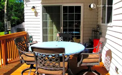 a table and four chairs on a porch at Charming Waterfront Cottage Rental near Topsmead State Forest, Connecticut in Harwinton