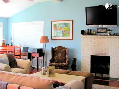 a living room with a couch and a fireplace at Charming Waterfront Cottage Rental near Topsmead State Forest, Connecticut in Harwinton