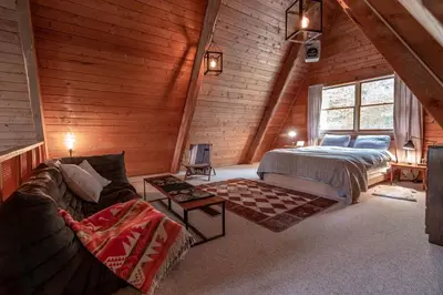 a bedroom with a bed and a couch in a room at Stunning A-Frame Cabin Rental in the Catskills near Albany, New York in Kingston