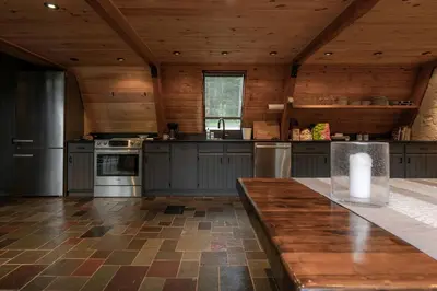 a large kitchen with wooden walls and a wooden ceiling at Stunning A-Frame Cabin Rental in the Catskills near Albany, New York in Kingston