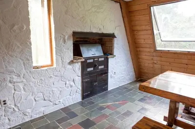a room with a stone wall with a stove in it at Stunning A-Frame Cabin Rental in the Catskills near Albany, New York in Kingston