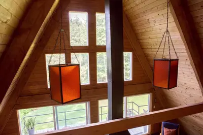 three lights hanging from the ceiling of a cabin at Stunning A-Frame Cabin Rental in the Catskills near Albany, New York in Kingston