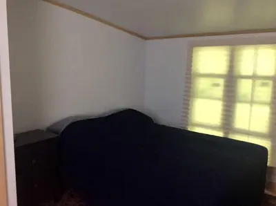 a bedroom with a black bed and a window at Rustic Couples' Cabin for Idyllic Catskills Getaway, Upstate New York in Shandaken