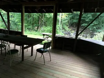a screened in porch with a table and chairs at Superb Family Cabin with Mountain Views and Deck in Shandaken, New York in Shandaken