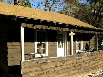 a log cabin with a porch and white doors at Superb Family Cabin with Mountain Views and Deck in Shandaken, New York in Shandaken