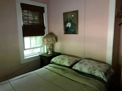 a bedroom with a bed and a lamp and a window at Superb Family Cabin with Mountain Views and Deck in Shandaken, New York in Shandaken