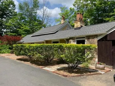 a house with a clock tower on top of it at Luxurious Riverfront Cottage with a Hot Tub and a Fireplace near the Twin Lakes, Connecticut in Canaan