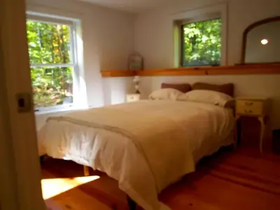 a bedroom with a large bed and two windows at Modern and Family-Friendly Vacation Rental in the Berkshires near Great Barrington in Monterey