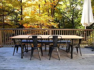 a wooden table with chairs and an umbrella on a deck at Modern and Family-Friendly Vacation Rental in the Berkshires near Great Barrington in Monterey