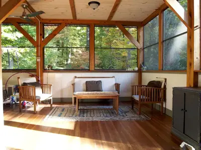 a screened in porch with two chairs and a table at Modern and Family-Friendly Vacation Rental in the Berkshires near Great Barrington in Monterey