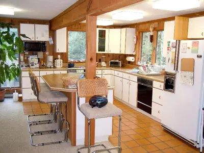 a kitchen with white cabinets and a counter with stools at Family-Friendly Cabin in the Deerfield Valley of Mount Snow, West Dover Vermont in West Dover