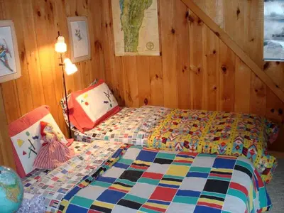 a bedroom with a bed with a colorful quilt at Family-Friendly Cabin in the Deerfield Valley of Mount Snow, West Dover Vermont in West Dover