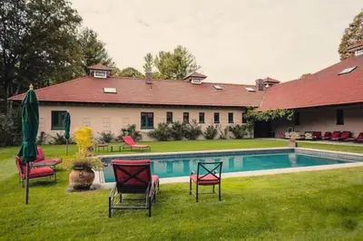 a house with a yard with chairs and a swimming pool at Gorgeous Green Mountains Vacation Rental with a Pool in Manchester, Vermont in Manchester Center