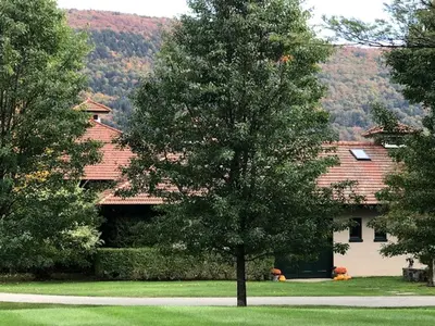 a house with a tree in front of it at Gorgeous Green Mountains Vacation Rental with a Pool in Manchester, Vermont in Manchester Center