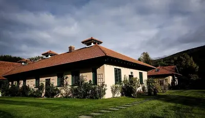 a white house with a brown roof on a green field at Gorgeous Green Mountains Vacation Rental with a Pool in Manchester, Vermont in Manchester Center