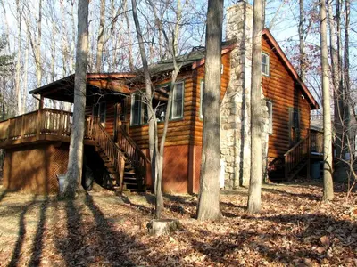 a log cabin in the woods with trees at Idyllic Waterfront Log Cabin in Wayne County Overlooking Lake Wallenpaupack, Pennsylvania in Lakeville