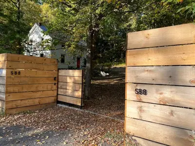 two wooden fences in front of a house at Modern Cottage Perfect for Glamping in New York State in Accord