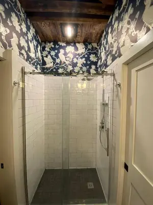 a bathroom with a shower with blue and white wallpaper at Modern Cottage Perfect for Glamping in New York State in Accord