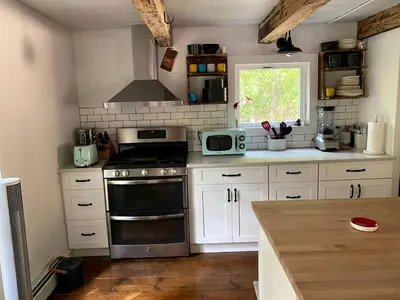 a kitchen with white cabinets and a stove top oven at Modern Cottage Perfect for Glamping in New York State in Accord