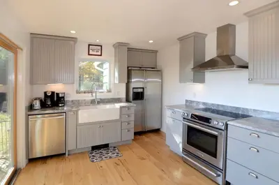 a kitchen with white cabinets and stainless steel appliances at Fabulous New York Cottage Rental near Ashokan Reservoir in Glenford