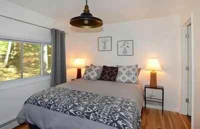 a bedroom with a bed and two lamps and a window at Fabulous New York Cottage Rental near Ashokan Reservoir in Glenford