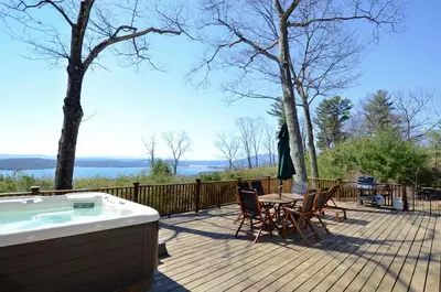 a deck with a hot tub and a table and chairs at Fabulous New York Cottage Rental near Ashokan Reservoir in Glenford