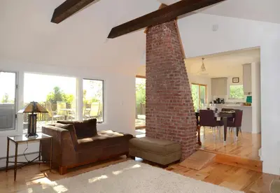 a living room with a couch and a brick pillar at Fabulous New York Cottage Rental near Ashokan Reservoir in Glenford
