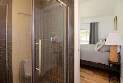 a glass shower in a bedroom with a bed at Fabulous New York Cottage Rental near Ashokan Reservoir in Glenford