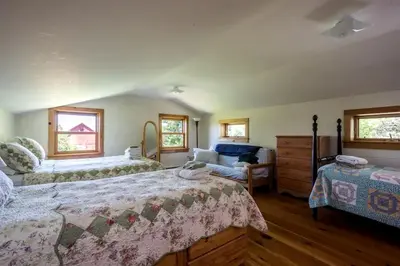 a bedroom with two beds and a couch and windows at Secluded Cottage Rental with a Fireplace in Greenville, New York in Greenville