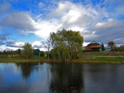 a large lake with a house in the background at Unique Vacation Rental on a Working Farm near Hudson, New York in Hudson