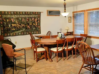 a dining room with a wooden table and chairs at Enormous Family-Friendly Cabin Rental in Shawangunk Mountains, New York in Pine Bush