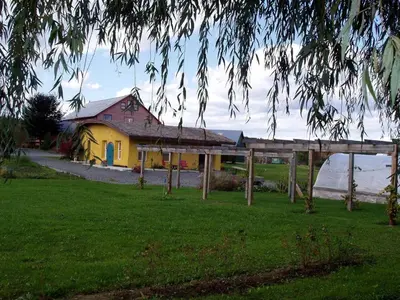 a house with a yellow building in a field at Pet-Friendly Cottage in a Working Farm near Hudson, New York in Hudson