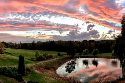 a sunset over a pond in a field at Pet-Friendly Cottage in a Working Farm near Hudson, New York in Hudson